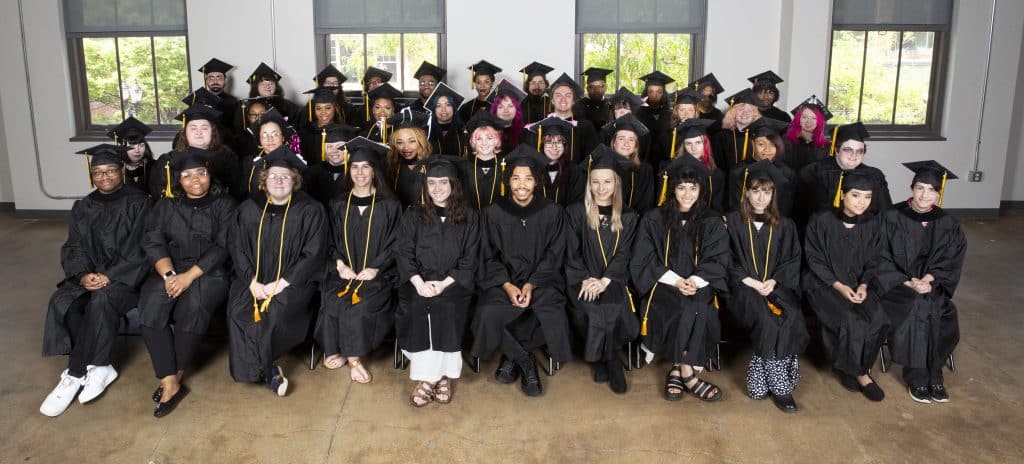 DCAD's Class of '23, about 60 students, seated in rows in their commencement robes